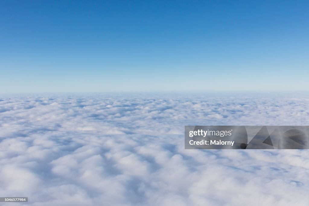 Aerial view, above the clouds. Clear blue sky