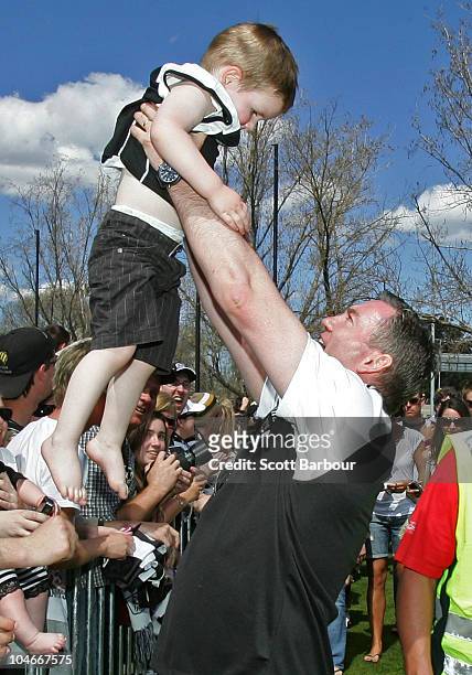 Collingwood President Eddie McGuire holds a young boy from the crowd aloft during the Collingwood Magpies AFL Grand Final reception at Gosch's Park...