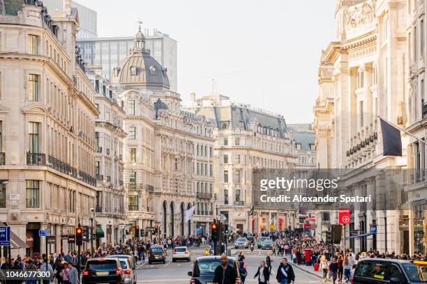 regent street with crowds of people, heavy traffic and lots of shops, london, england, uk - oxford street stock-fotos und bilder