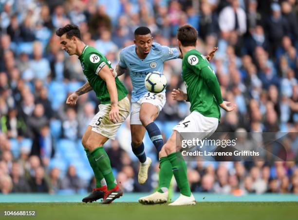 Gabriel Jesus of Manchester City is tackled by Lewis Dunk and Davy Propper of Brighton during the Premier League match between Manchester City and...