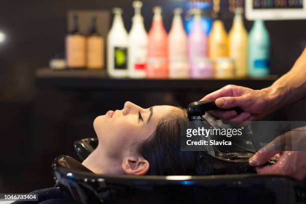 mujer de lavar el cabello en peluquería - lavarse el cabello fotografías e imágenes de stock