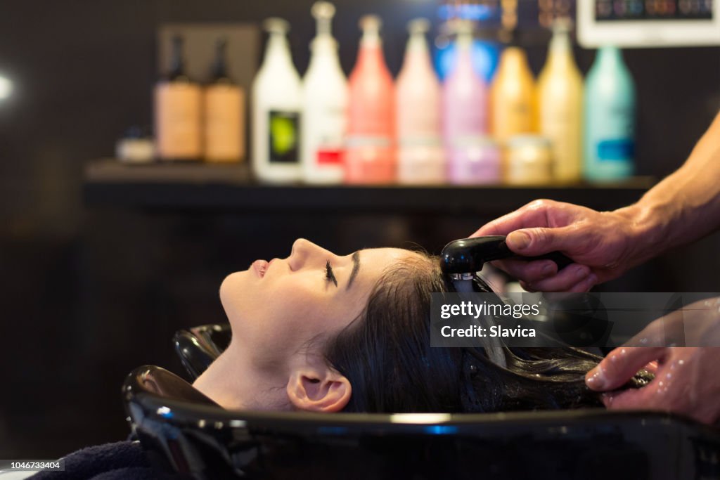 Woman washing hair in hair salon