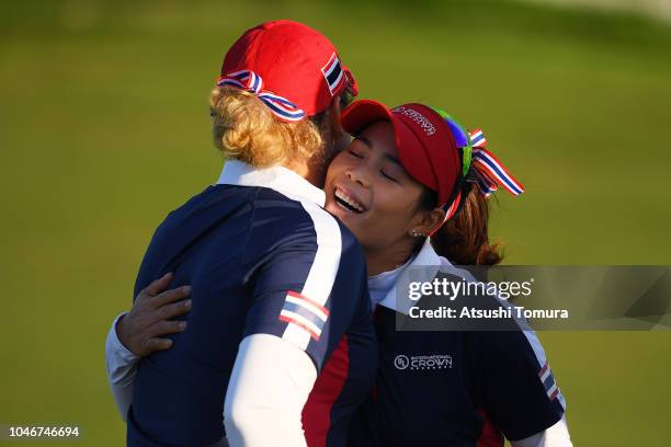 Moriya Jutanugarn and Ariya Jutanugarn of Thailand celebrate their victory on the 17th green in the Pool B Match between Thailand and Sweden on day...