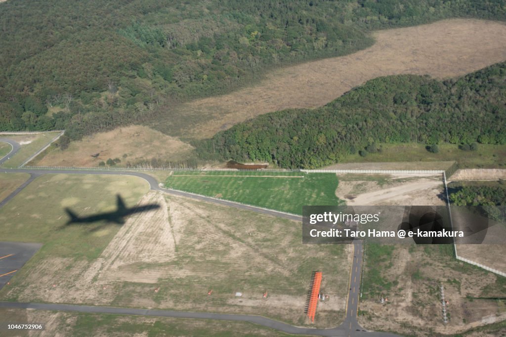 The silhouette of airplane taking off Hokkaido New Chitose Airport (CTS) in Japan daytime aerial view from airplane