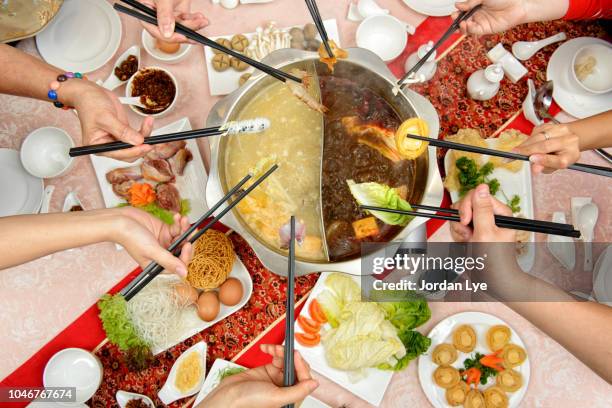 chopsticks with food of a steamboat meal - hot pots stockfoto's en -beelden