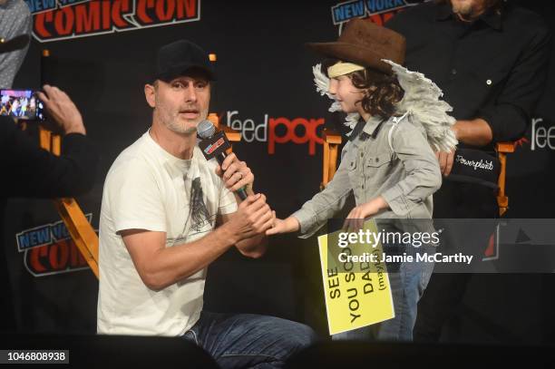 Andrew Lincoln speaks to a cosplayer dressed as Carl Grimes onstage during the NYCC panel and fan screening of "The Walking Dead" episode 901 at The...