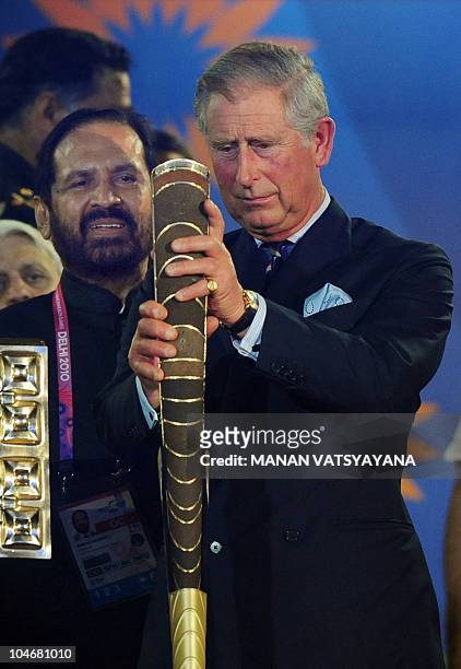 Britain's Prince Charles, Prince of Wales places the Queen's Baton in its holder as Commonwealth Games Organising Committee Chairman Suresh Kalmadi...