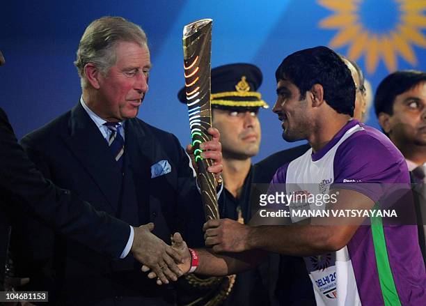 Britain's Prince Charles, Prince of Wales receives the Queen's Baton from Indian wrestler Sushil Kumar during the XIX Commonwealth Games opening...