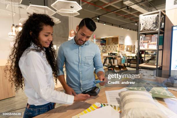 man shopping at a furniture store paying by credit card - furniture shop stock pictures, royalty-free photos & images