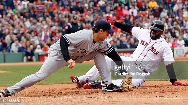 Mark Teixeira of the New York Yankees executes the second out of a double play on base runner David Ortiz of the Boston Red Sox, who was caught off...