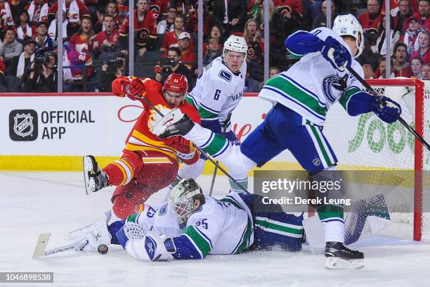 Mikael Backlund of the Calgary Flames takes a shot on Jacob Markstrom of the Vancouver Canucks during an NHL game at Scotiabank Saddledome on October...