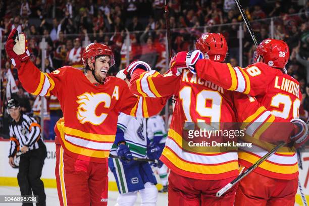 Sean Monahan, Matthew Tkachuk, and Elias Lindholm celebrate after Lindholm scored the game-winning goal against the Calgary Flames celebrates of the...