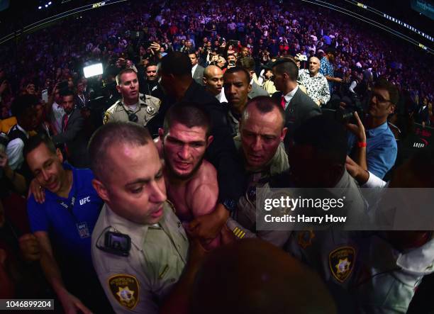 Khabib Nurmagomedov of Russia is escorted out of the arena after defeating Conor McGregor of Ireland in their UFC lightweight championship bout...