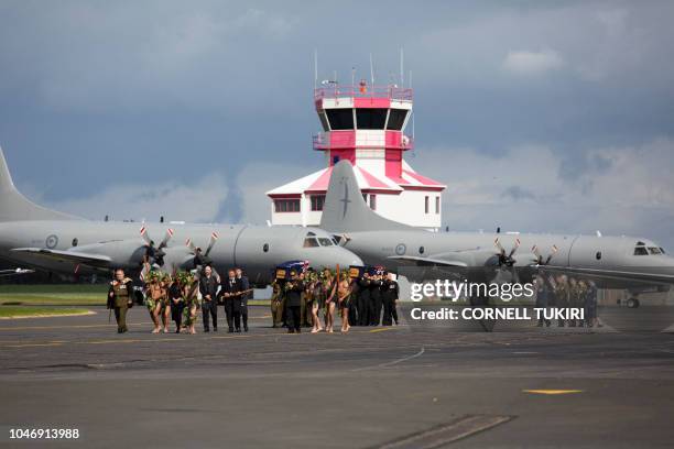 Pallbearers from the New Zealand Defence Force carry caskets during an arrival ceremony for the repatriated remains of two New Zealand military...