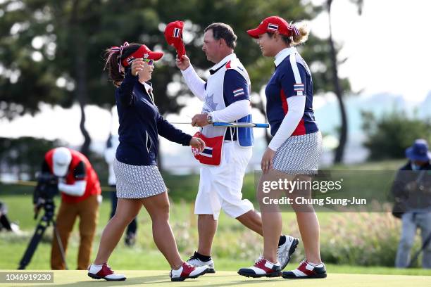 Ariya Jutanugarn of Thailand is congratulated by Moriya Jutanugarn after her victory on the 17th green during the Singles match against Sung Hyun...