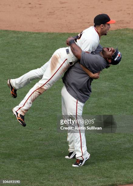 Pablo Sandoval of the San Francisco Giants lifts teammate Andres Torres after they clinched the National League West divsion against the San Diego...