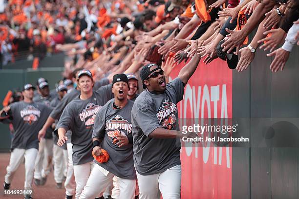 Members of the San Francisco Giants celebrate after defeating the San Diego Padres to win the National League West during a Major League Baseball...