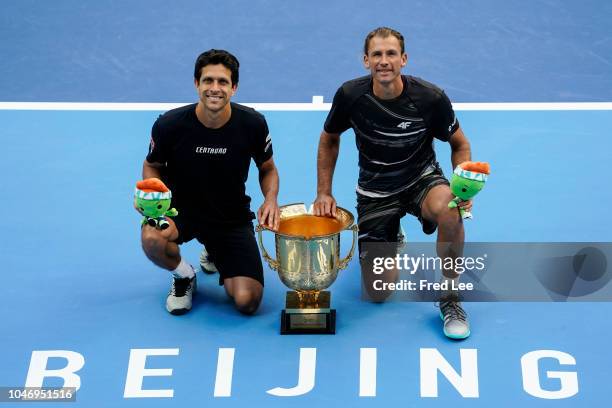 Lukasz Kubot of Poland and Marcelo Melo of Brazil poses with his trophies during the medal ceremony after the Men's doubles final match against...