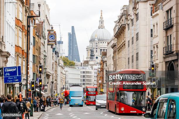 busy street in city of london with heavy traffic, crowds of people and dome st. paul's cathedral - london stockfoto's en -beelden