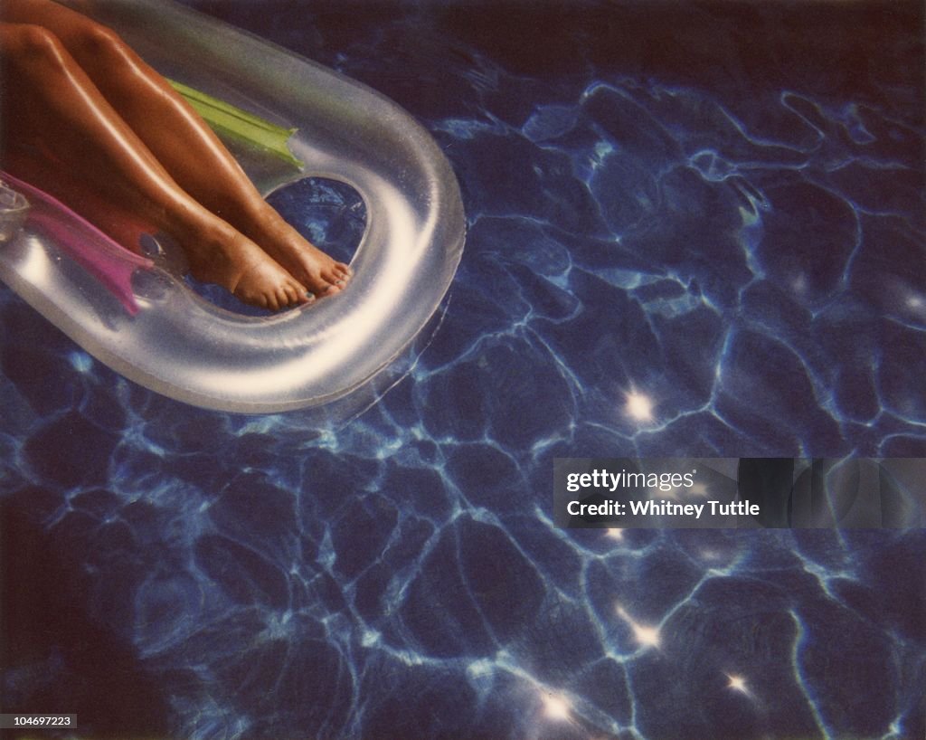 Girl tanning legs in swimming pool