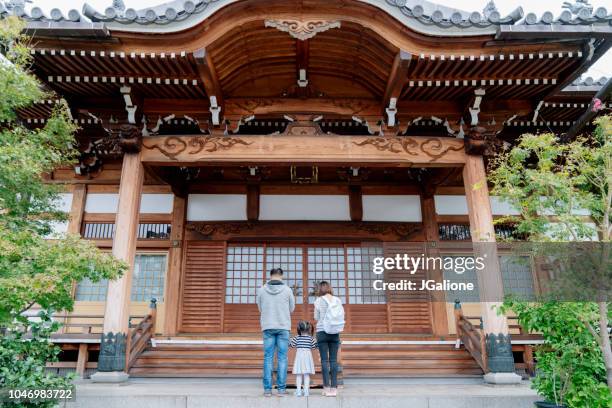 familj av turister be på en japansk temple - helgedom bildbanksfoton och bilder