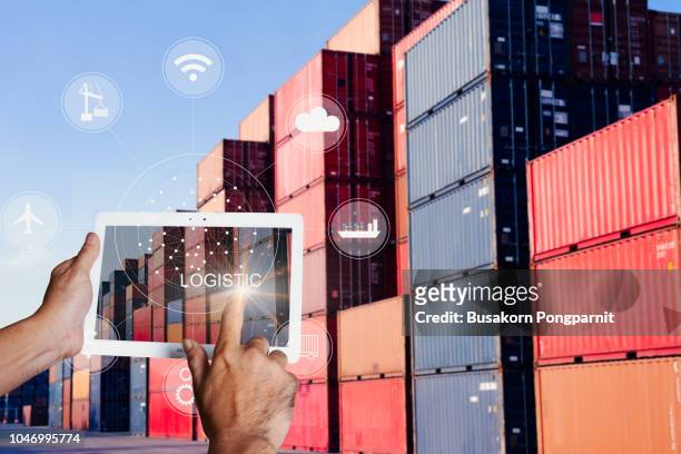 businessman hand holding tablet touch screen technology interface global partner connection for logistic import export background - chonburi province stock photos et images de collection