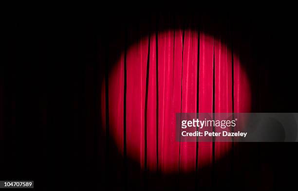spot light on red theatre curtains - spotlicht stockfoto's en -beelden