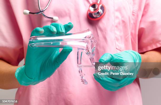 gynaecologist holding vaginal speculum - frauenarzt untersuchung stock-fotos und bilder