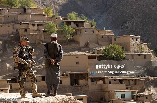 German Bundeswehr soldier drinks a cup of tea with a man during a patrol on October 4, 2010 in Kham-i-Awwal, Afghanistan. Germany has more than 4,500...