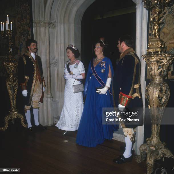 Queen Beatrix of the Netherlands and Queen Elizabeth II arrive at a state banquet held at Hampton Court Palace on November 18, 1982 .