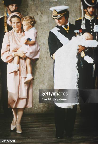 Queen Silvia and King Carl Gustav XVI of Sweden with Princess Victoria and baby Prince Carl Philip during his christening held at the Royal Chapel in...