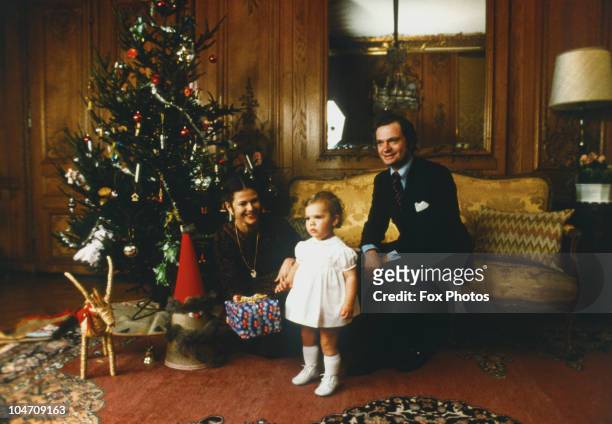 Queen Silvia and King Carl Gustaf XVI with young Princess Victoria celebrate Christmas at the Royal Palace in Stockholm in December 1978.