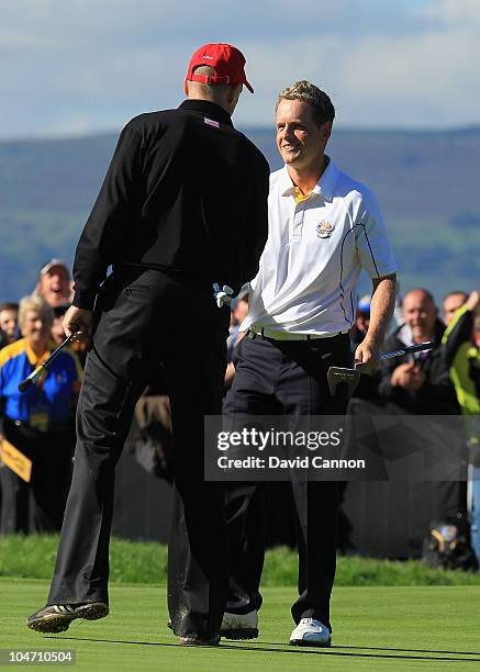 Luke Donald of Europe is congratulated by Jim Furyk of the USA after he won his match on the 18th green in the singles matches during the 2010 Ryder...