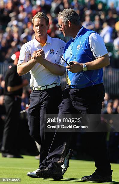 Luke Donald of Europe is congratulated by Vice Captain Darren Clarke after he won his match on the 18th green in the singles matches during the 2010...