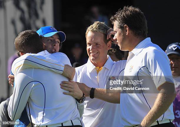 Rory McIlroy of Europe embraces Vice Captain Sergio Garcia on the 18th green after he halved his match in the singles matches during the 2010 Ryder...