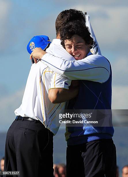 Rory McIlroy of Europe embraces Martin Kaymer on the 18th green after he halved his match in the singles matches during the 2010 Ryder Cup at the...
