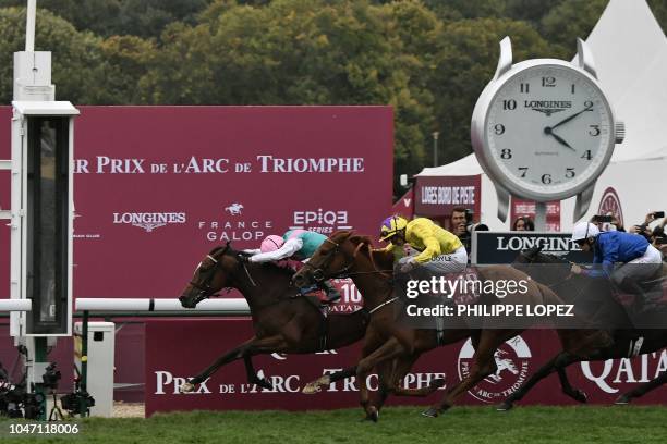 Italian jockey Frankie Dettori riding horse "Enable" leads to cross first the finish line followed by British jockey James Doyle on "Sea Of Class"...