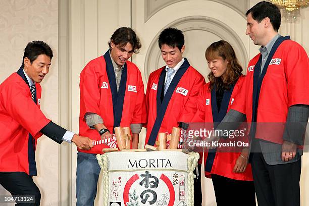 Former tennis player Shuzo Matsuoka, Rafael Nadal of Spain, Kei Nishikori of Japan and Ayumi Morita of Japan break open a sake barrel during a...