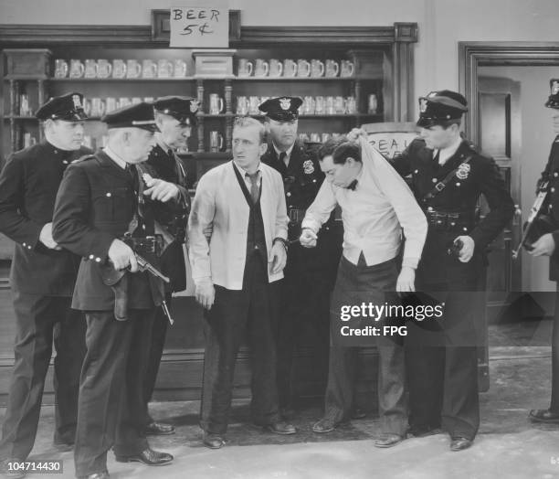 Jimmy Durante , American singer, pianist, comedian and actor, with American comic actor and silent film star Buster Keaton surrounded by a group of...