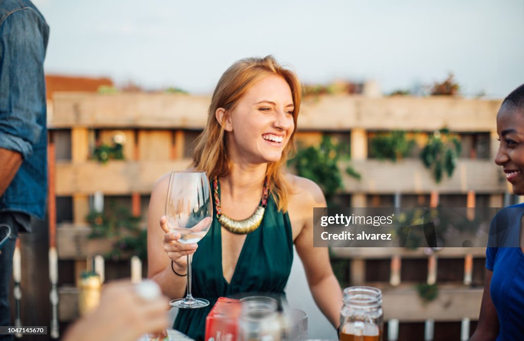 Multi-ethnischen Freunde mit Getränken auf Terrasse party