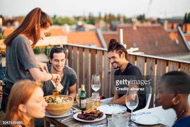 multi-ethnic group of friends at barbeque party on rooftop - rooftop bbq stock pictures, royalty-free photos & images
