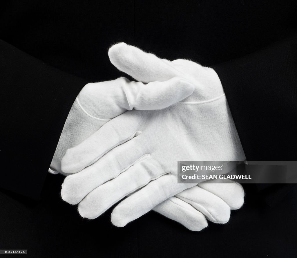 White gloves behind back