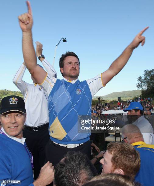 Graeme McDowell of Europe celebrates his 3&1 win to secure victory for the European team on the 17th green at the end of the singles matches during...