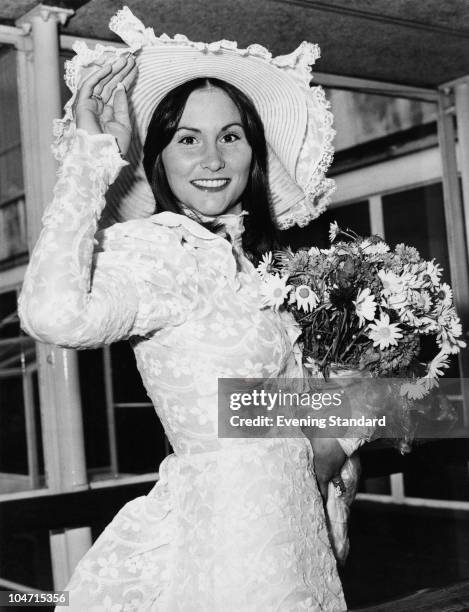 American pornographic actress Linda Lovelace arriving at London Airport , 28th May 1974. She is wearing a lace dress and matching hat.