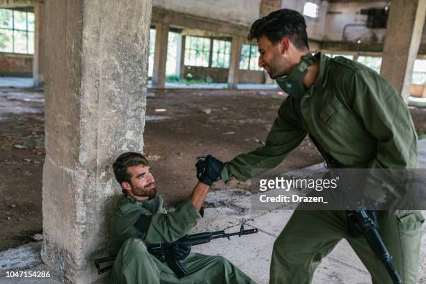 guerriers s’entraider dans la bataille - airsoft gun photos et images de collection