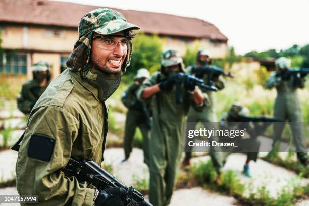 amigos que juegan al juego de guerra con armas de airsoft - arma de airsoft fotografías e imágenes de stock