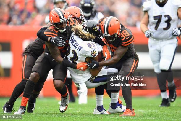 Willie Snead of the Baltimore Ravens is tackled by Damarious Randall of the Cleveland Browns and T.J. Carrie of the Cleveland Browns in the first...