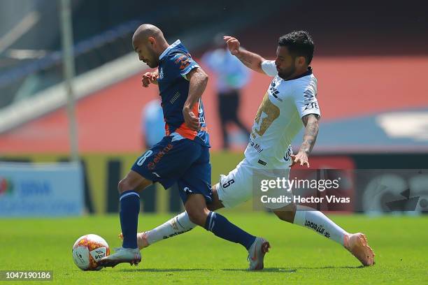 Aldo Arellano of Queretaro struggles for the ball with Alan Mendoza of Pumas during the 11th round match between Pumas UNAM and Puebla as part of the...