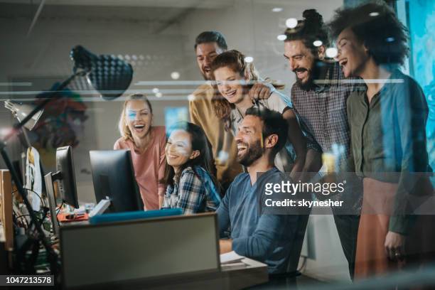 team of happy programmers having fun while working on desktop pc in the office. - millennial generation stock pictures, royalty-free photos & images