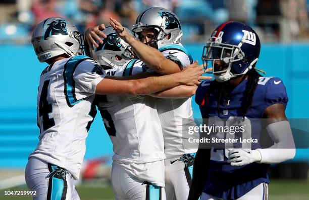 Teamamtes J.J. Jansen and Michael Palardy celebrate with Graham Gano of the Carolina Panthers after he made a 63 yard field goal to win the game as...